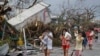 Residents cover their nose from the smell of dead bodies in Tacloban city, Leyte province central Philippines on Sunday, Nov. 10, 2013. 