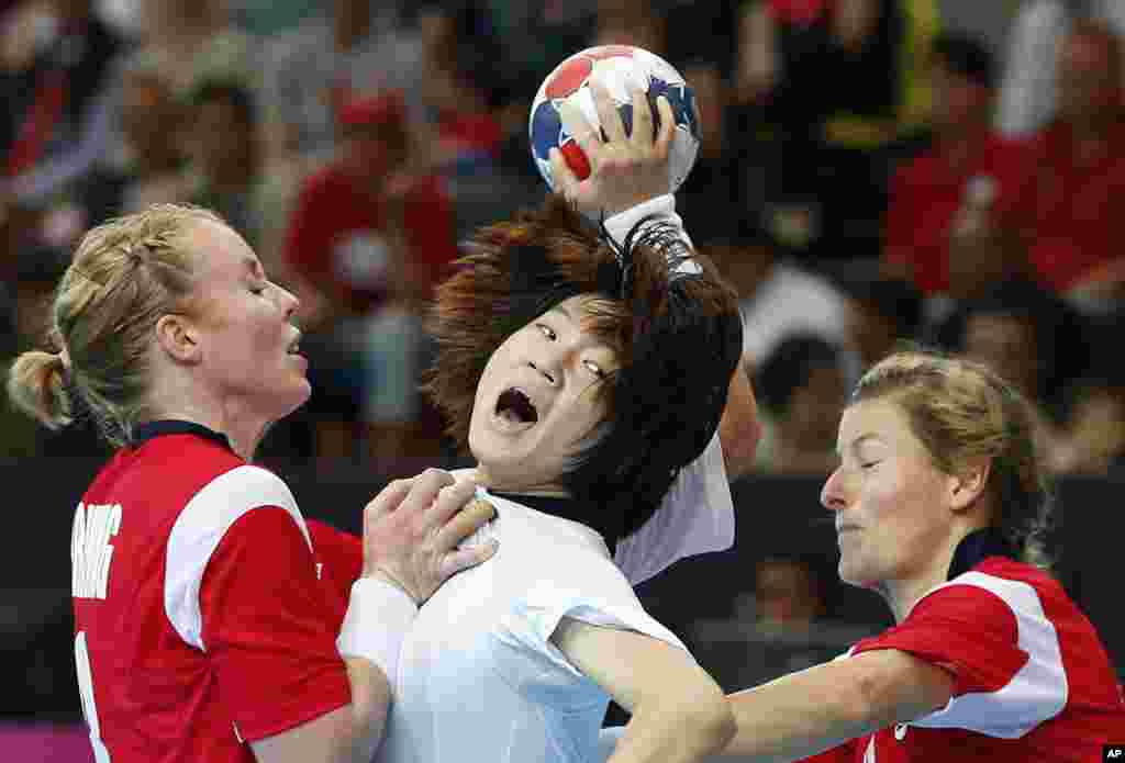 South Korea&#39;s Jo Hyo-bi, center is tackled by Norway&#39;s Karoline Dyhre Breivang, left, and Lynn-Kristin Koren, right, during their women&#39;s handball preliminary match at the 2012 Summer Olympics, Aug. 1, 2012, in London. 