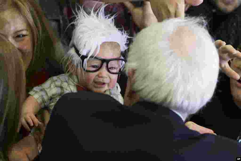 Democratic presidential candidate Sen. Bernie Sanders, an Independent from Vermont, right, meets 3-month-old Oliver Lomas, of Venice, California, who was dressed as Sanders during a rally at Bonanza High School in Las Vegas, Nevada, Feb. 14, 2016.