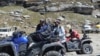 People sit on their all terrain vehicles at Rohtang Pass, India, Sept. 20, 2013. (Anjana Pasricha for VOA) 