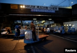 Workers drive vehicles known as turret trucks at the Tsukiji fish market in Tokyo, Japan, Sept. 25, 2018.