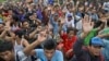 FILE - In this April 3, 2015 photo, rescued Burmese fishermen raise their hands as they are asked who among them wants to go home at the compound of Pusaka Benjina Resources fishing company in Benjina, Aru Islands, Indonesia. Two Indonesians and five Thai were arrested on charges of human trafficking connected with slavery in the seafood industry, Indonesian police said on May 12.