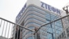 Men pass by a building of Chinese tech giant ZTE in Beijing, China, May 8, 2018.