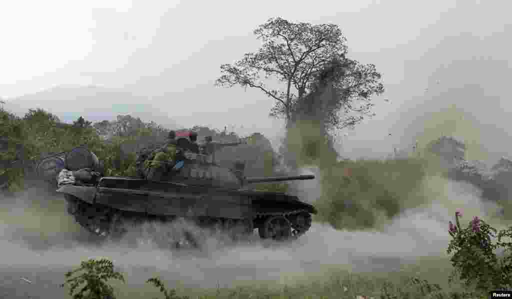 Sebuah tank Angkatan Bersenjata Kongo (FARDC) mengeluarkan tembakan dalam pertempuran antara tentara Kongo dengan Pemberontak M23 di Kibati, di luar Goma di timur Republik Demokratik Kongo. 