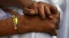 Seorang penderita kusta mengenakan "Rakhi" (benang suci) saat berlangsungnya festival Raksha Bandhan di Kushat Aashram, rumah bagi orang yang terkena kusta, di kota Chandigarh, India utara, 5 Agustus 2009. (REUTERS/Ajay Verma)
