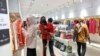 Warga mengenakan masker saat melihat-lihat pakaian di sebuah pusat perbelanjaan di Jakarta, Jumat, 30 Desember 2022. (AP/Tatan Syuflana)