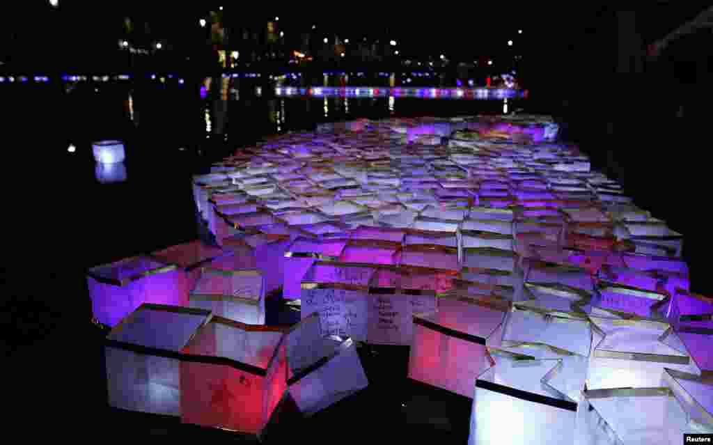 Warga Perancis melepas semacam &#39;lentera kertas&#39; dengan lilin di Canal Saint-Martin di Paris, untuk memperingati setahun serangan teror yang menewaskan 130 orang.