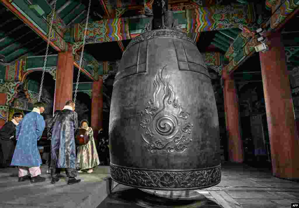 Para peserta memukul lonceng besar untuk menyambut Hari Tahun Baru 2025, selama perayaan setelah tengah malam di paviliun Bosingak di pusat kota Seoul, Korea Selatan, 1 Januari 2025. (AFP)&nbsp;