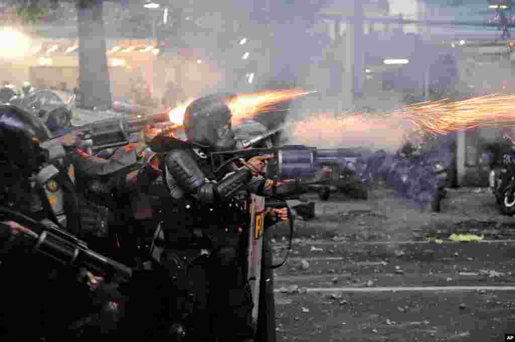 Police officers fire tear gas launchers during a clash with student protesters in Bandung, West Java, Indonesia.&nbsp;Thousands of students and workers protested against a new law they say will cripple labor rights and harm the environment.