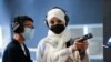 Saudi female firearm trainer, Mona Al Khurais, teaches a Saudi boy on safe usage of weapons at the Top-Gun shooting range in Riyadh, Saudi Arabia, October 28, 2021. Picture taken October 28, 2021. REUTERS/Ahmed Yosri