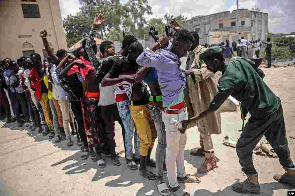 A Somali soldier checks a man at the entrance before a handover ceremony as the African Union Mission to Somalia (AMISOM) leaves Mogadishu stadium in Mogadishu.