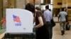 People cast their votes at a polling station inside the Enoch Pratt Free Library's central library branch in Baltimore, April 26, 2016.