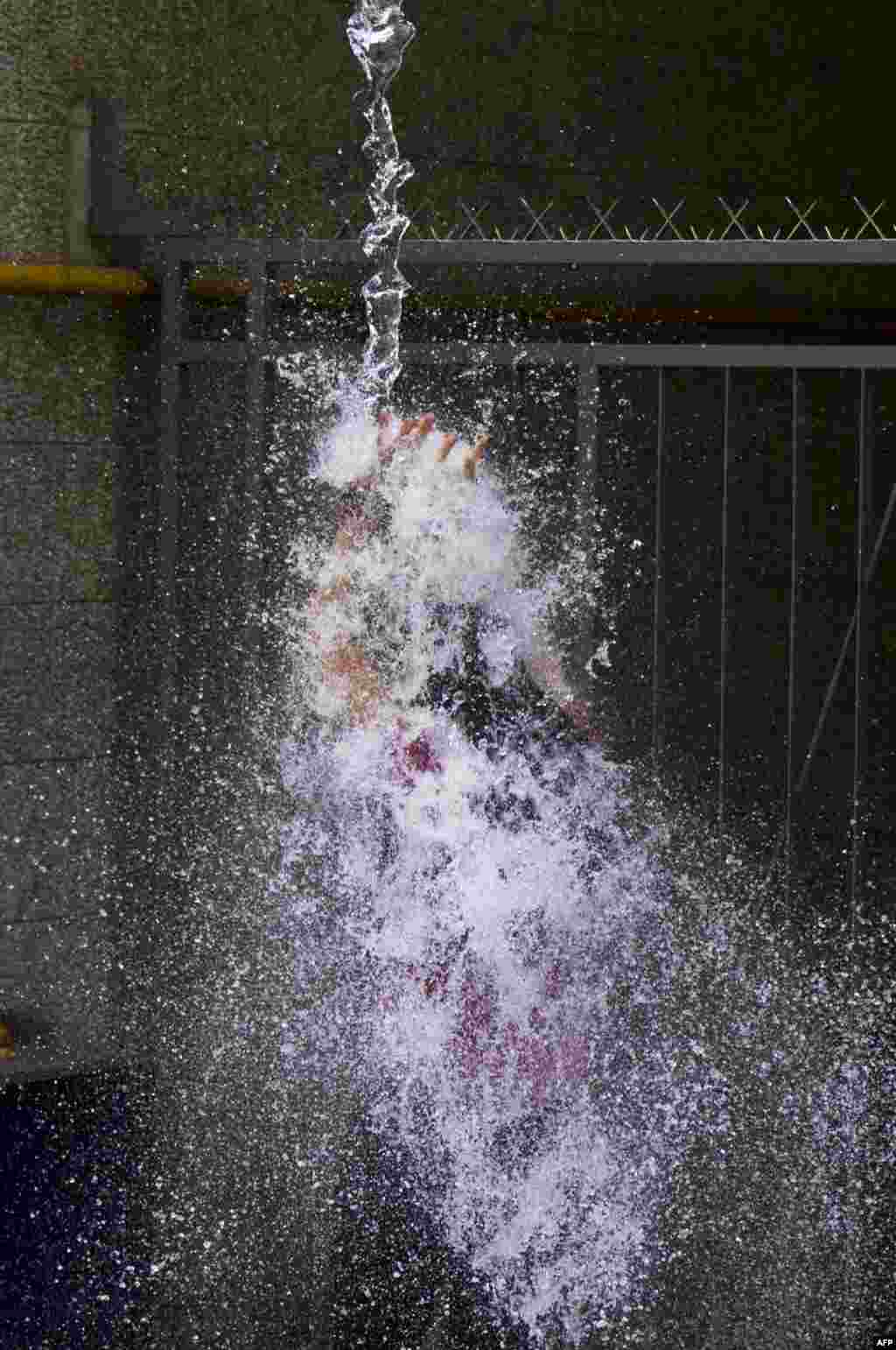 A woman is drenched with water splashed from an office in Montevideo's old district, Uruguay, as a way of celebrating the end of the year.