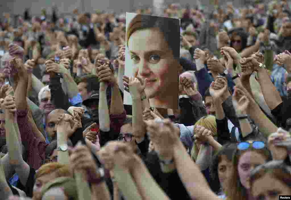 Orang-orang bergandengan tangan saat menghadiri acara khusus di Lapangan Trafalgar London, Inggris untuk mengenang anggota parlemen dari Partai Buruh, Jo Cox, yang terbunuh.