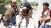 FILE - A fighter of Libyan forces allied with the U.N.-backed government runs for cover while carrying a wounded fighter during a battle with IS fighters in Sirte, Libya, July 31, 2016. Extremists have continued to exploit Libya's political chaos.