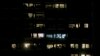 FILE - Apartments are illuminated in a building in Vienna, Austria, March 28, 2020. Incidents of domestic violence have gone up during coronavirus shutdowns.
