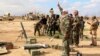 Iraqi army soldiers and volunteers prepare to launch mortar shells and rockets against Islamic State militant positions outside Tikrit, March 4, 2015.