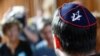 A member of Jewish community wearing a kippah talks to the media before the trial of a Syrian charged with assault at the Moabit court in Berlin, June 19, 2018.