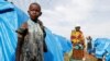 FILE - A girl who had part of her arm chopped off by militiamen when they attacked her village of Tchee, stands in a camp for internally displaced people in Bunia, Ituri province, Democratic Republic of Congo, April 12, 2018.