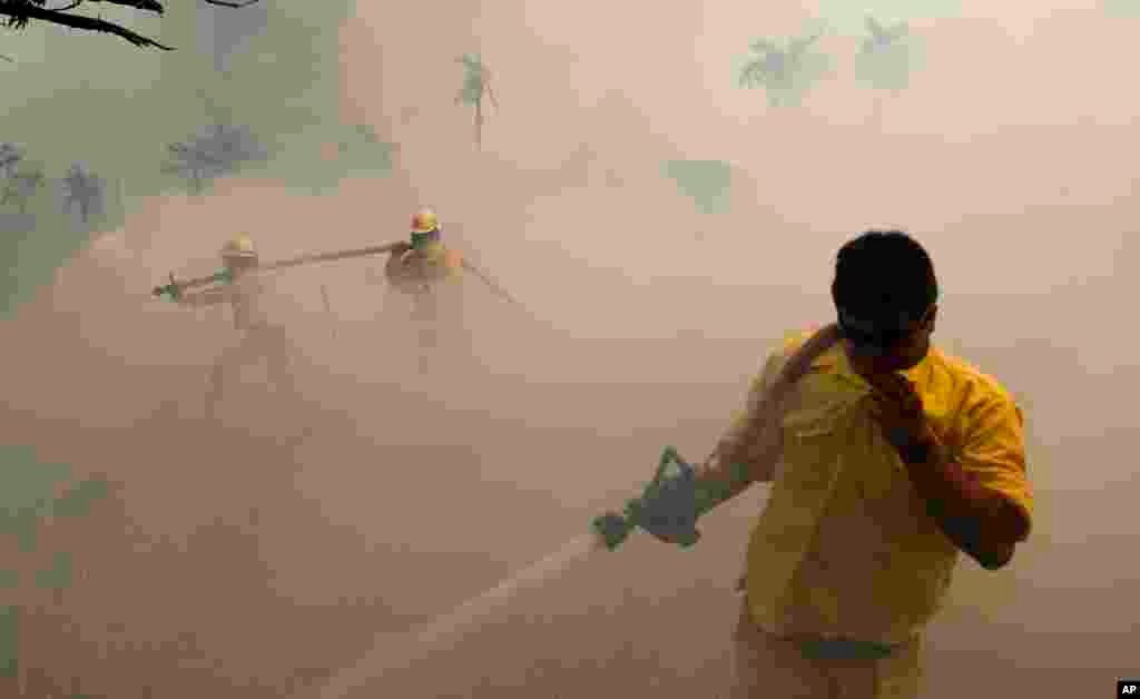 Firefighters work to put out flames burning grasslands near Altos, Paraguay.