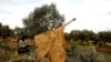 Syrian fighters set a target to an artillery near Idlib, Syria, Feb. 27, 2020.
