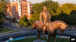The statue of Confederate Gen. Robert E. Lee is bathed in the late sun on Monument Avenue in Richmond, Va., Sept. 6, 2021. 