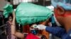 A health worker checks the temperature of a passenger, amid the spread of the coronavirus disease, at a railway station in Mumbai, India, March 17, 2021.