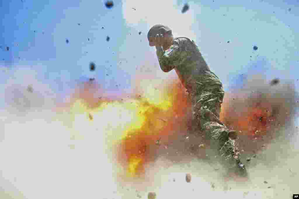 Gambar yang dirilis oleh Angkatan Darat AS. ini menunjukkan seorang tentara Afghanistan terbakar api saat sebuah tabung mortir meledak ketika &nbsp;tentara Angkatan Darat Afghanistan sedang melakukan latihan pemadam kebakaran di Provinsi Laghman. Fotografer pasukan tempur Angkatan Darat AS Spc. Hilda Clayton mengambil foto ini pada tanggal 2 Juli 2013. Kecelakaan tersebut menewaskan Clayton dan empat tentara Tentara Nasional Afghanistan.