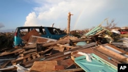 A rainbow rises over the extensive damage and destruction in the aftermath of Hurricane Dorian in The Mudd, Great Abaco, Bahamas, Thursday, Sept. 5, 2019.