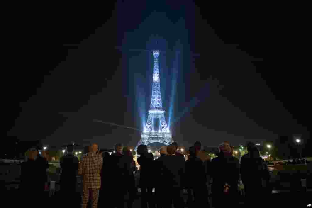 The Eiffel Tower is illuminated in the colors of the "Fashion loves Paris" campaign during the Paris Fashion Week in France.