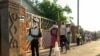 FILE - People line up for a food handout amid the coronavirus pandemic, in Chitungwiza, Zimbabwe, May 5, 2020.