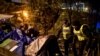 French police talk to migrants during an evacuation operation in Paris, Nov. 7, 2019. More than 1,000 migrants and homeless have settled in this area for months. 