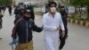 Policemen arrest a doctor in the course of a protest during a government-imposed nationwide lockdown as a preventive measure against the coronavirus, in Quetta, April 6, 2020.