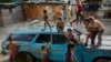 FILE - Children play on top of an abandoned car at the "Aguerridos Liberator" shanty town in Caracas, Venezuela, May 9, 2019. 