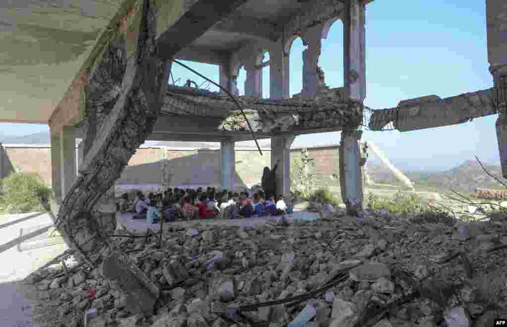 Yemeni pupils attend class on the first day of the new academic year, in a makeshift classroom in their school compound which was heavily damaged two years ago in an airstrike, in the country&#39;s third-city of Taez.