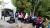 FILE - A line of asylum seekers who said they were from Haiti wait to enter into Canada from Roxham Road in Champlain, New York, Aug. 7, 2017.