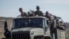 FILE - Ethiopian government soldiers ride in the back of a truck on a road near Agula, north of Mekele, in the Tigray region of northern Ethiopia, May 8, 2021.