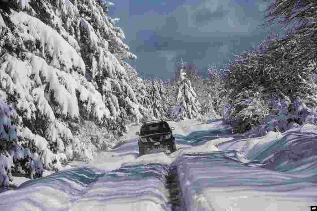 A car drives on a snow-covered near the small village of Opakua, northern Spain.