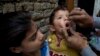 FILE - A Pakistani health worker gives a polio vaccine to a child in Islamabad, Dec. 8, 2014.