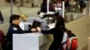 FILE - A foreign airline passenger hands travel documents to a Customs and Border Protection Officer at Hartsfield-Jackson International Airport in Atlanta, Georgia, Jan. 5, 2004. 