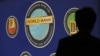 A man is silhouetted against the logo of the World Bank at the main venue for the International Monetary Fund (IMF) and World Bank annual meeting in Tokyo, October 10, 2012. 