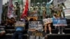 Activists stage a protest outside the Chinese Consulate, guarded by Philippine police, on the fifth anniversary of an international arbitral court ruling invalidating Beijing's historical claims over the waters of the South China Sea, in Makati City, Philippines on July 12, 2021.