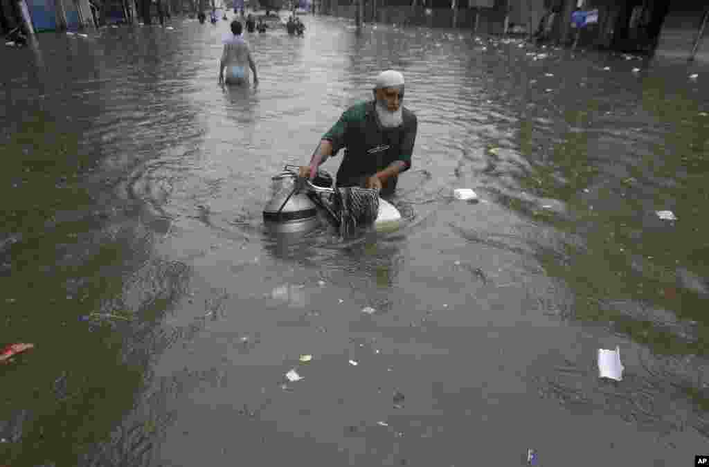 A cyclist navigates through a flooded road after heavy monsoon rains, in Lahore, Pakistan.