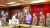 မြန်မာနယ်စပ် အွန်လိုင်းငွေလိမ်ဂိုဏ်းလက်က ပြန်လွတ်လာသူ တရုတ်မင်းသား Wang Xing က သတင်းစာရှင်းလင်းပွဲအပြီး ထိုင်းရဲအရာရှိကိုလက်ဆွဲနှုတ်ဆက်နေစဥ်။ (ဇန်နဝါရီ ၇၊ ၂၀၂၅)