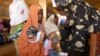 A health worker (R) vaccinates a child at a public health center where children are being vaccinated against polio in Kano, northern Nigerian, on February 13, 2013.