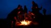 Turkish Kurds sit around a fire to warm themselves as they watch the Syrian town of Kobani from a hill near the Mursitpinar border crossing, on the Turkish-Syrian border in the southeastern town of Suruc, Turkey, Oct. 22, 2014.