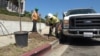 LA Conservation Corps crew supervisor Jeff Davis helps corps member plant a sapling curbside in Los Angeles.