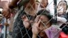 Typhoon survivors queue up at Tacloban city airport hoping to be able to board U.S. and Philippine military transport planes, Nov. 13, 2013, in Tacloban city, Leyte province in central Philippines. 