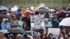 FILE - A person holds a sign that reads "Fund Climate Change Research - Saving the Planet Is Not a Waste of Money" during the March for Science in Washington, April 22, 2017.