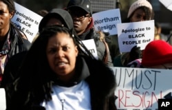 FILE - Demonstrators hold signs and chant outside the Governor's Mansion at the Capitol in Richmond, Virginia, Feb. 2, 2019. The protesters are calling for the resignation of Virginia Gov. Ralph Northam after a decades-old photo with a blackface is unearthed in his school yearbook.